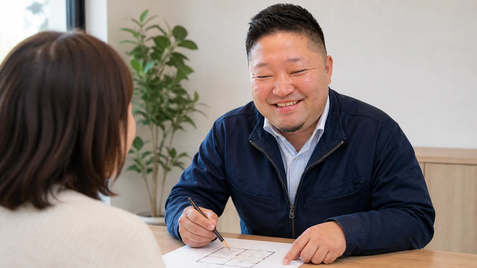 吉田社長が図面を使って説明する場面